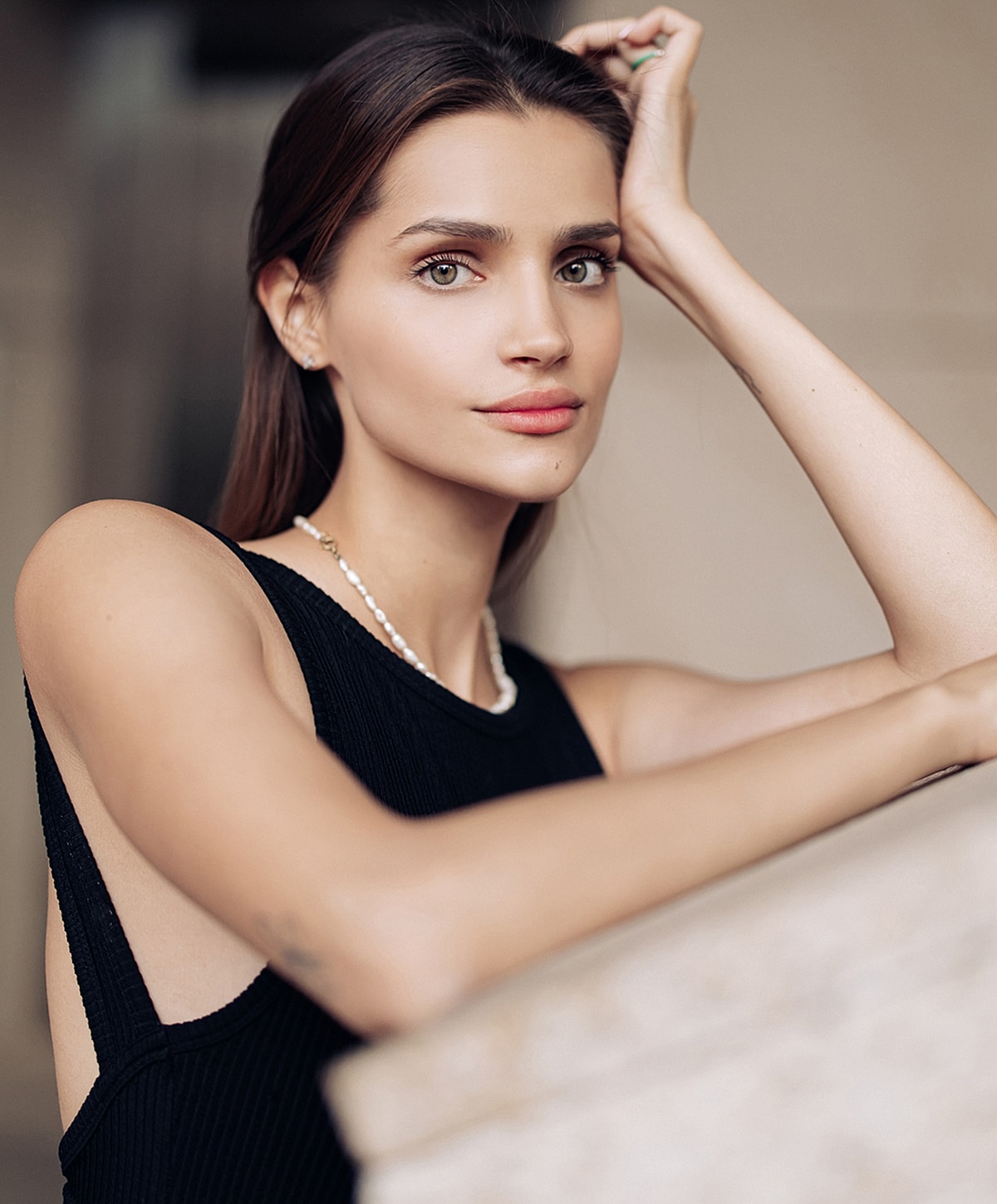 Woman posing elegantly with a thoughtful expression.