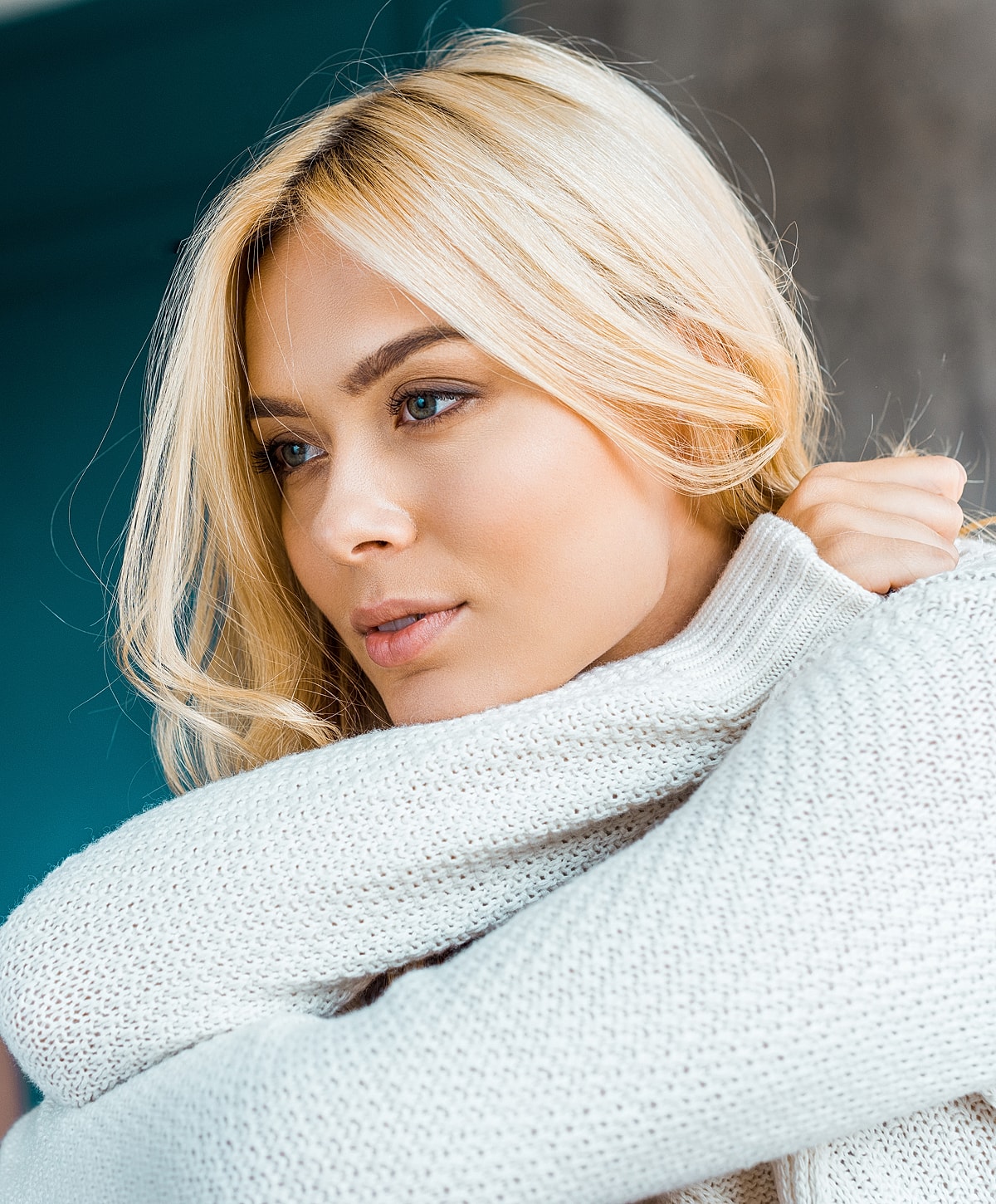 Woman in sweater with soft, thoughtful expression.