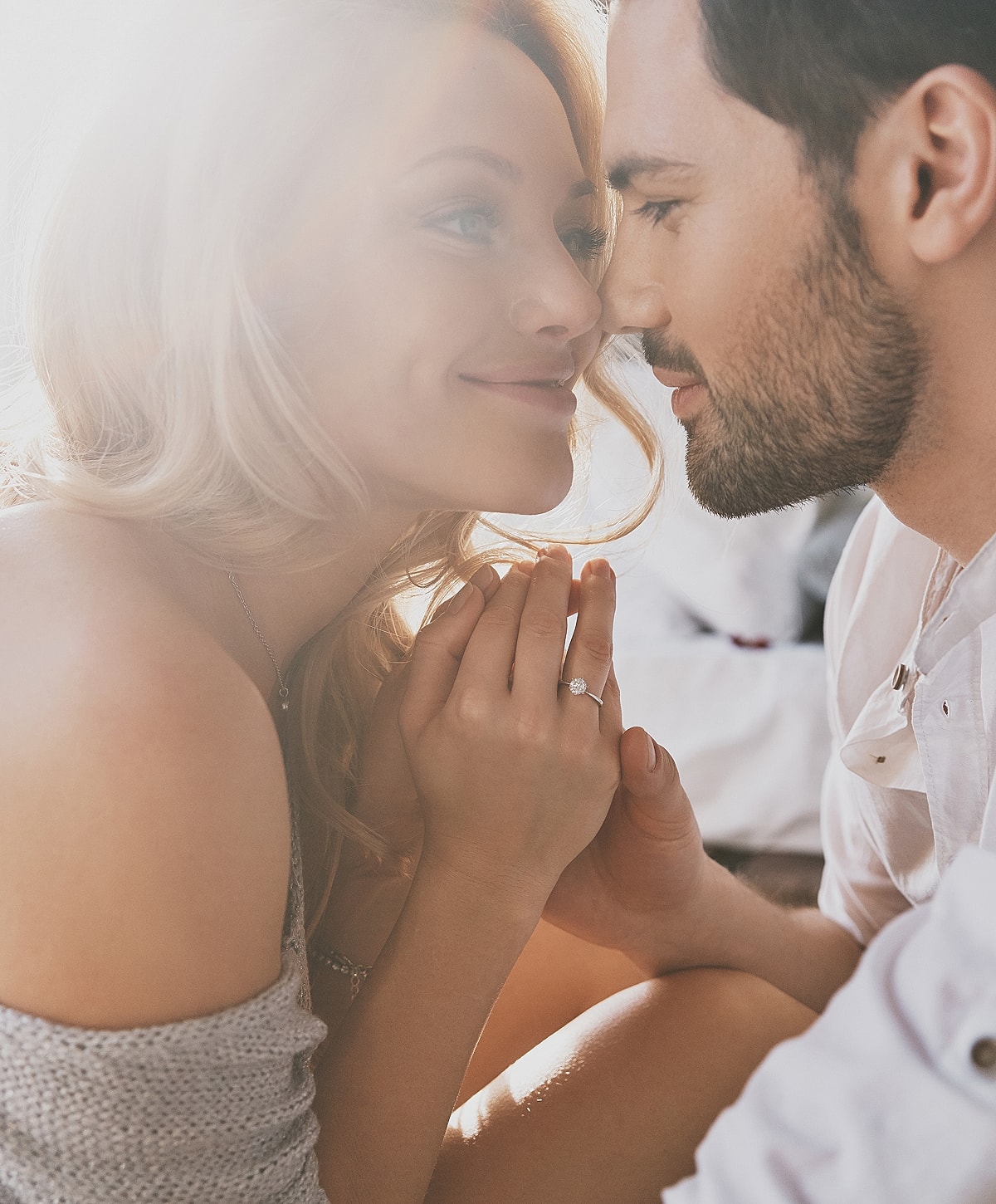 Couple sharing an intimate moment, sunlight ambiance.